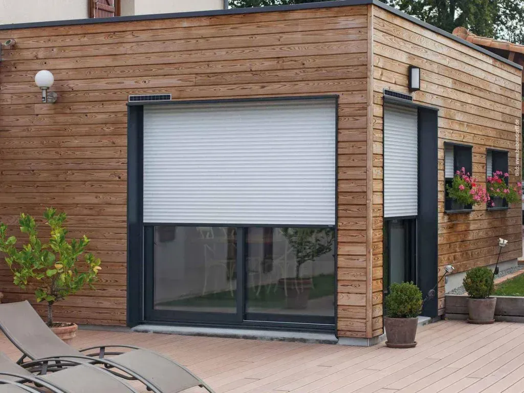 Ein Holzgebäude mit einem weißen Fensterladen. Bild von Bubendorff