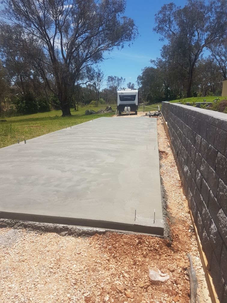 A Truck Is Driving Down A Concrete Driveway Next To A Brick Wall — Regional Concreting Solutions In Orange, NSW