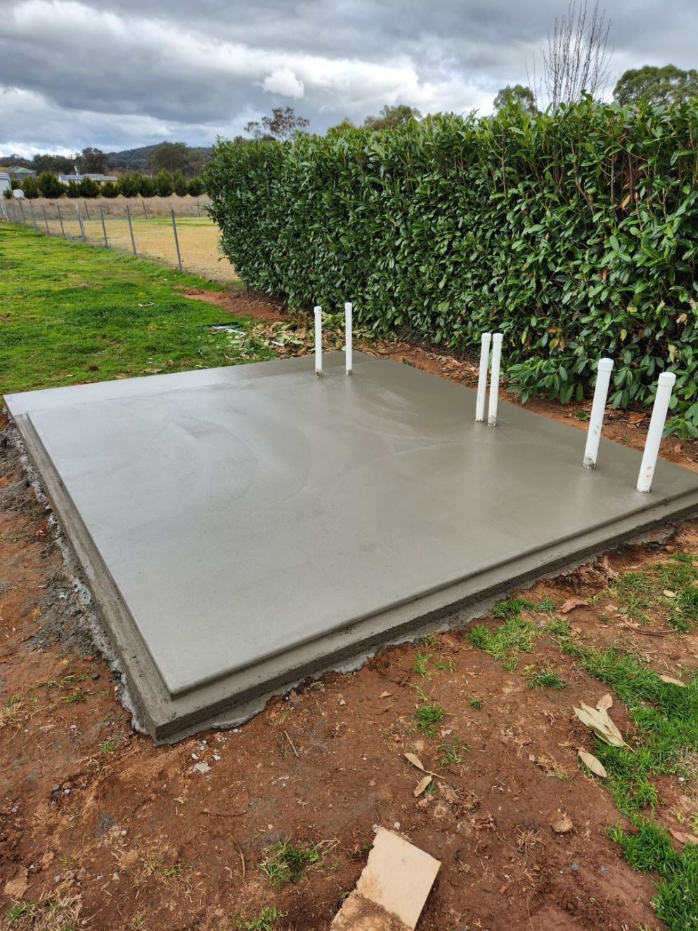 A Group Of Construction Workers Are Pouring Concrete Into A Foundation — Regional Concreting Solutions In Cudal, NSW