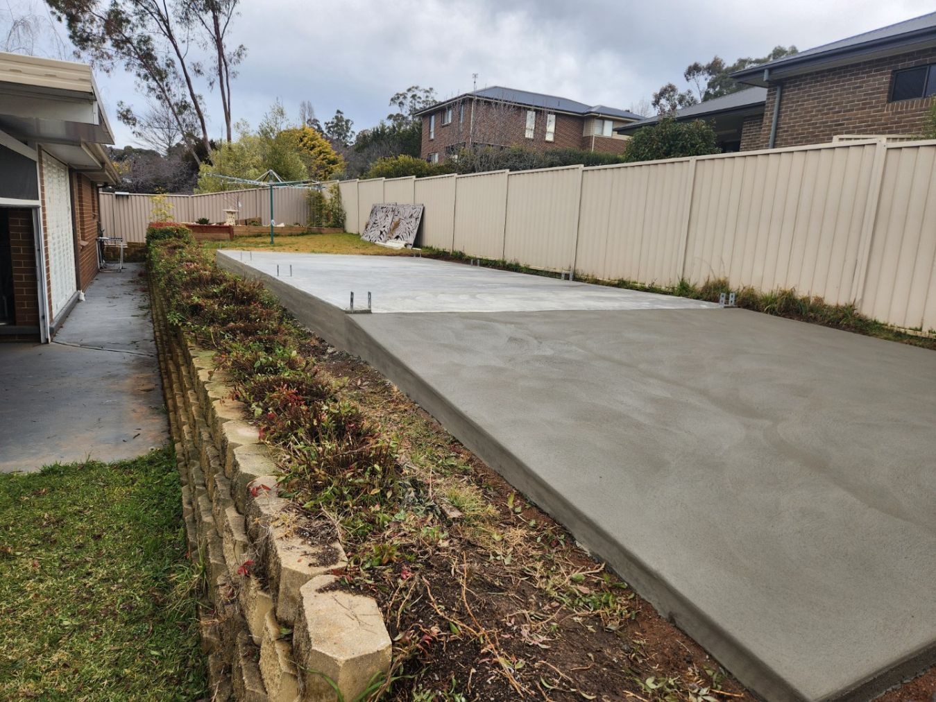 A Man Is Pouring Concrete Into A Foundation At A Construction Site — Regional Concreting Solutions In Bathurst, NSW