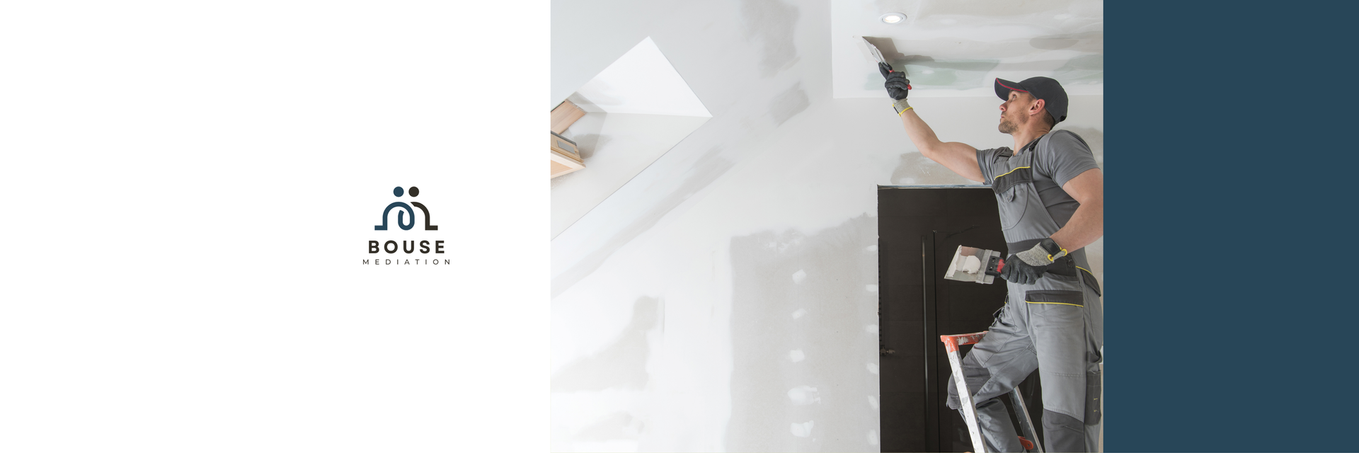 Man in a cap installing or painting a wall in a bright room with a tall dark cabinet nearby