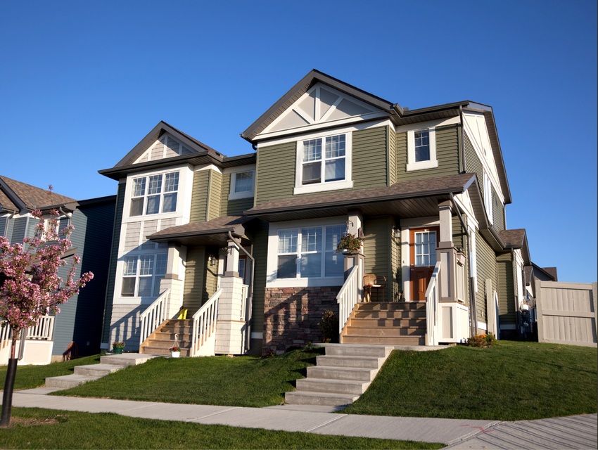 A modern green multi-family residential building exterior with a clear blue sky, next to a logo on a white background. A modern green multi-family residential building exterior with a clear blue sky, next to a logo on a white background.