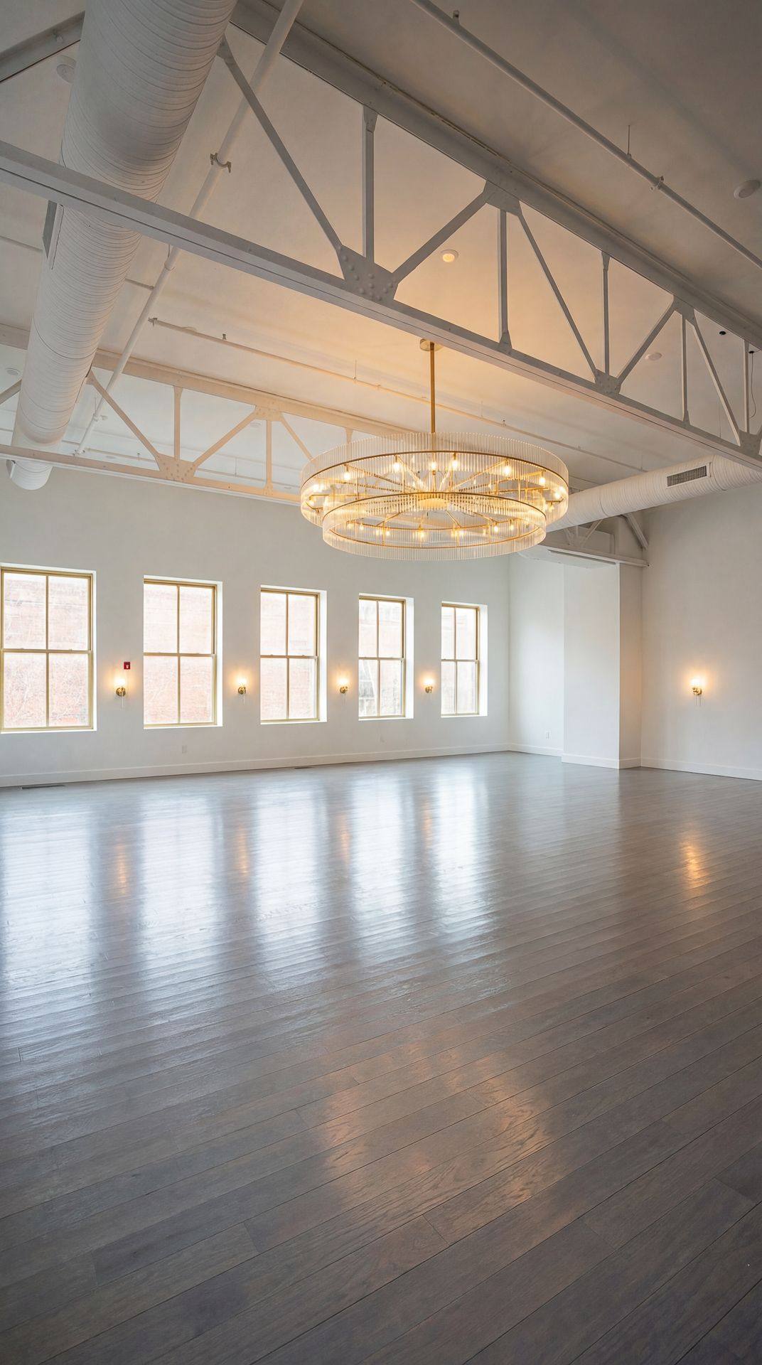Empty wedding hall at Casablanca with gold chairs and benches. Large chandelier hangs from white ceiling.