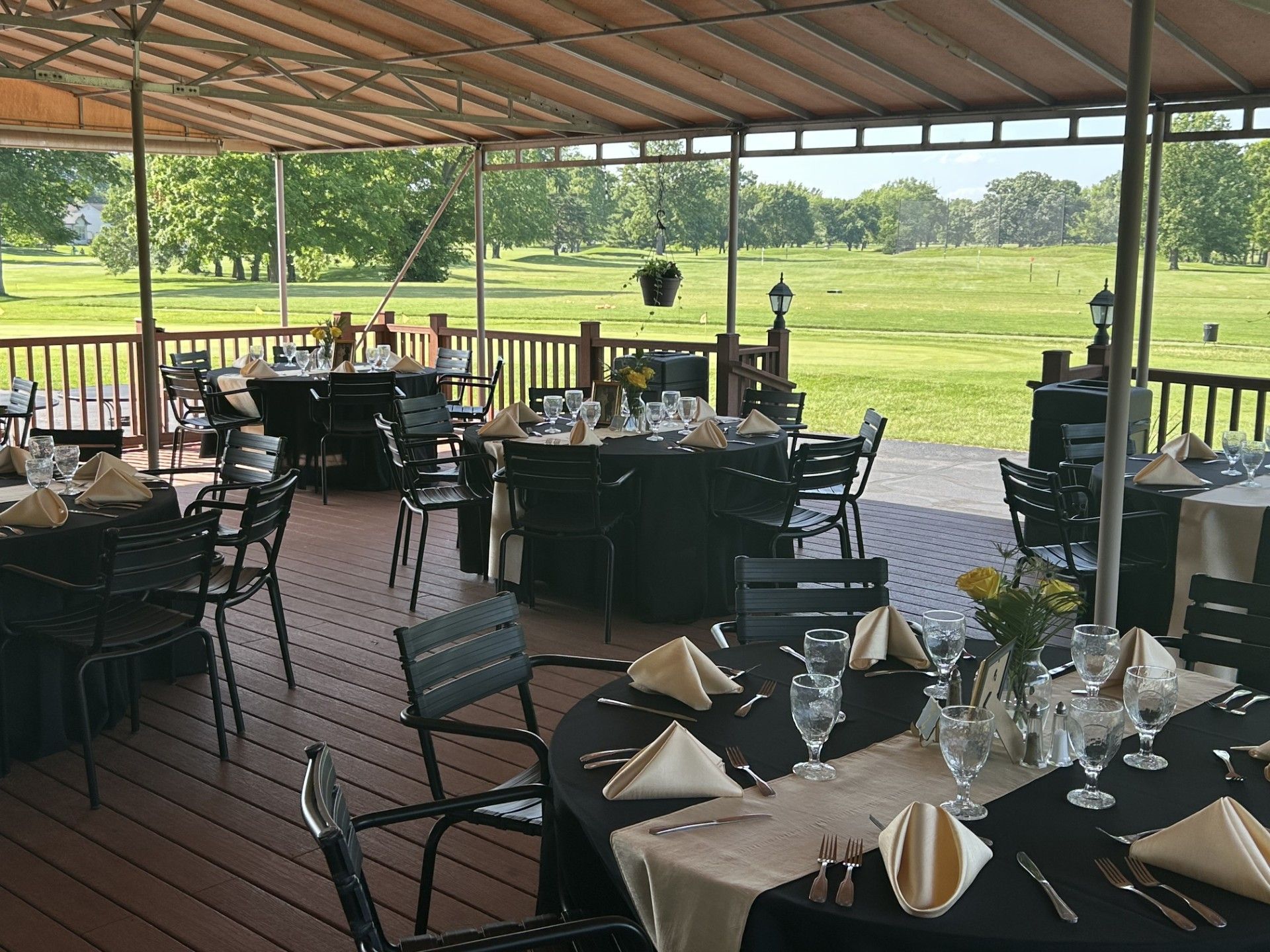 Banquet hall with tables set for a formal event, featuring a dance floor and large window.