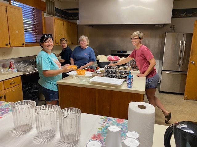 A group of women are preparing food in a kitchen.