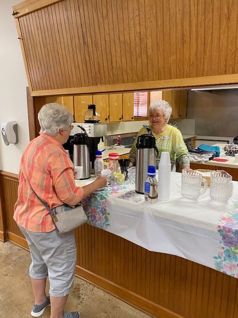 Two women are standing at a counter in a kitchen.