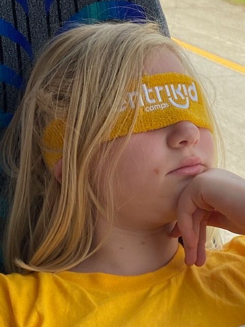 A girl wearing a yellow headband that says ' erikd ' on it