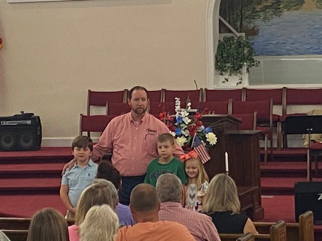 A man is standing in front of a crowd of people in a church.