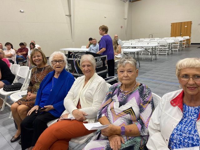 A group of older women are sitting in chairs in a room.
