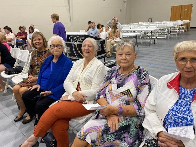 A group of older women are sitting in chairs in a room.