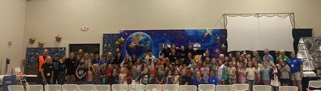 A large group of people are standing in a room.