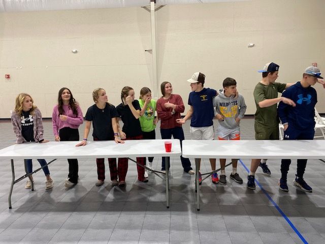 A group of young people are standing around a table