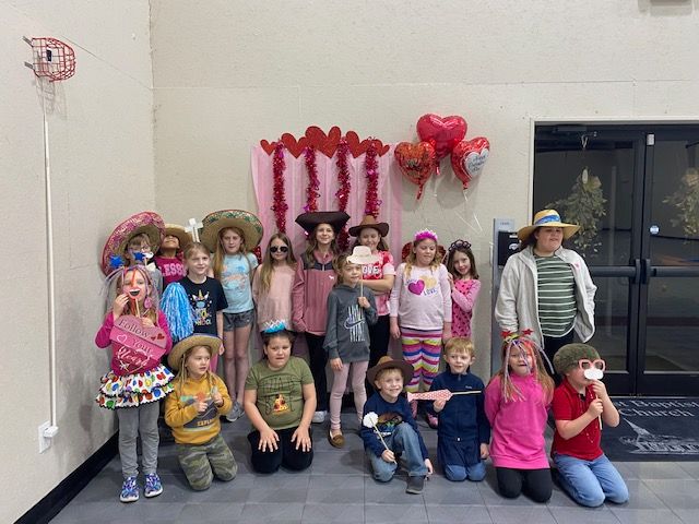 A group of children wearing cowboy hats are posing for a picture.
