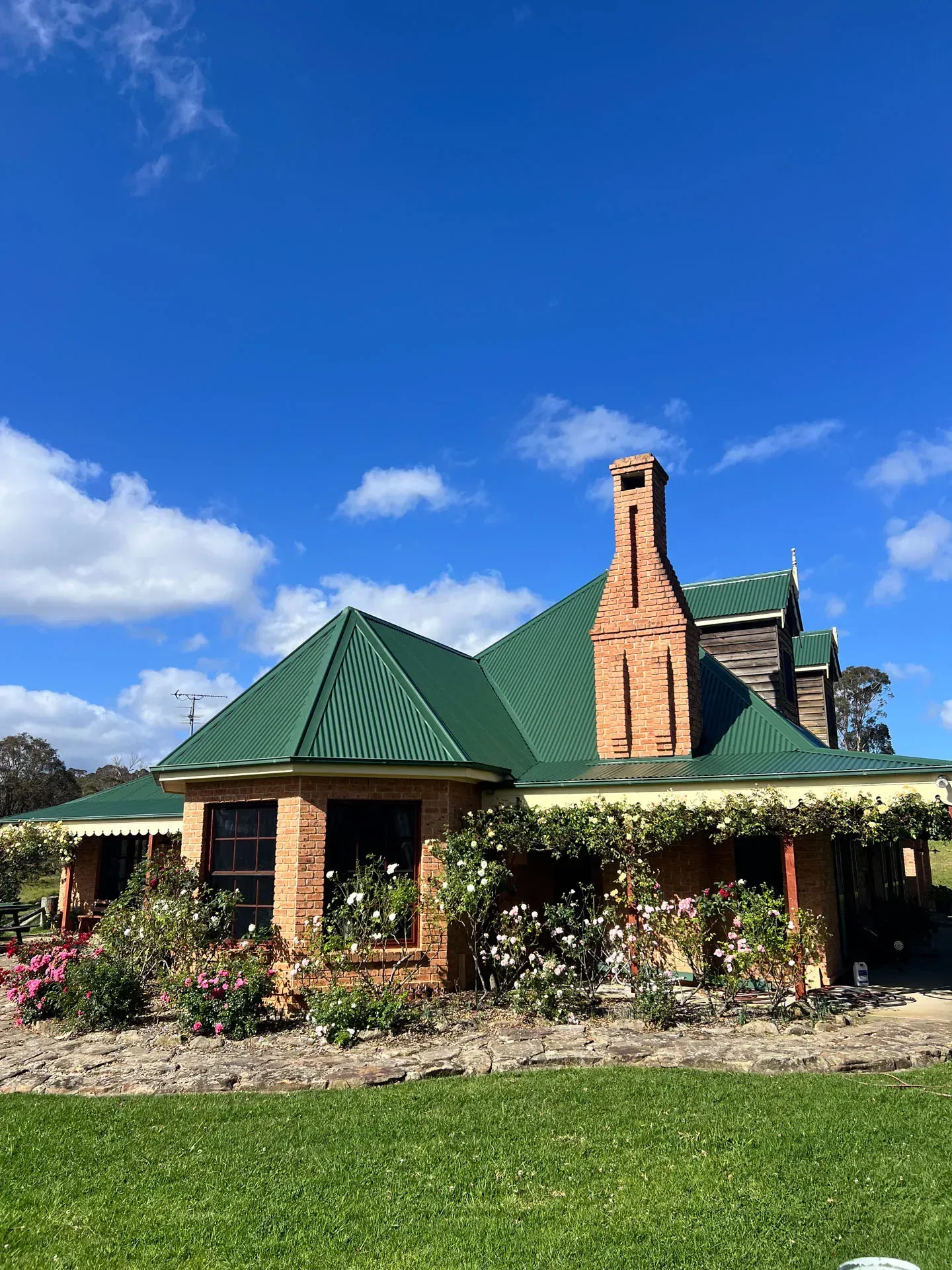 A large brick house with a green roof and a chimney.