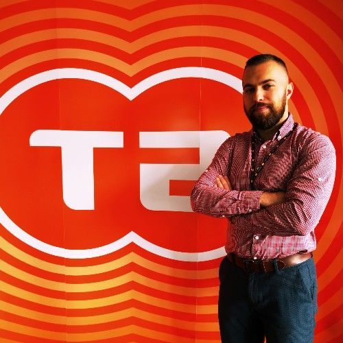 Man with crossed arms in front of orange 