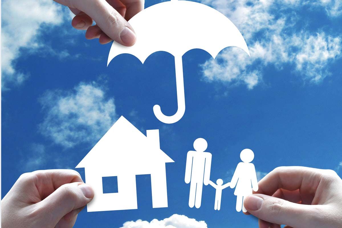 cutouts of umbrella over a house and family symbolizing insurance