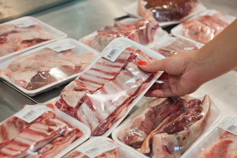 A Person Is Holding a Tray of Meat in A Butcher Shop — Prime Meats NT in Coconut Grove, NT