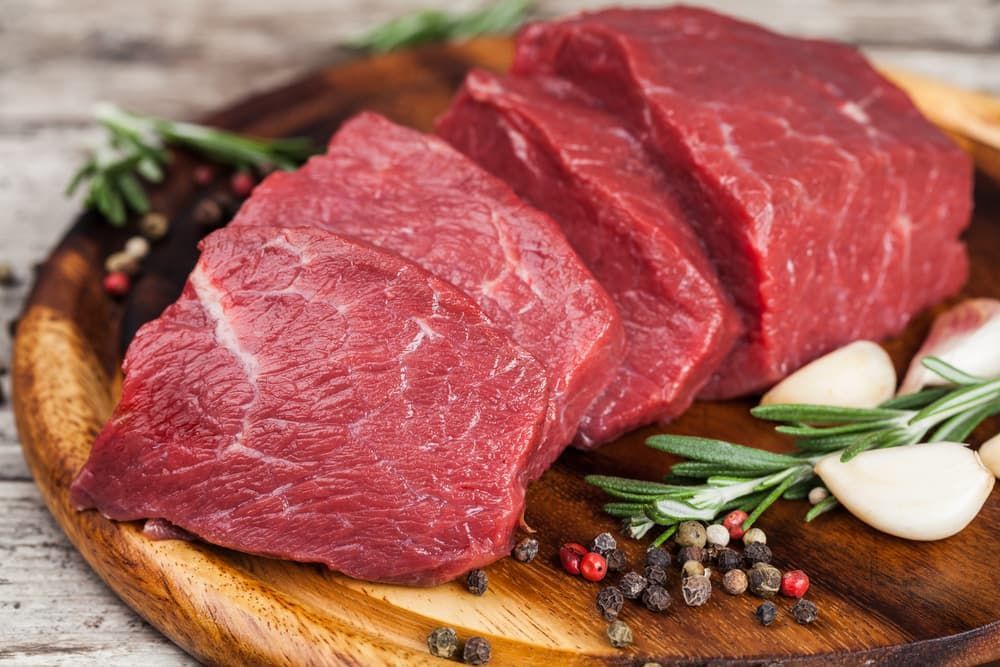 Raw Beef Steaks on A Wooden Cutting Board with Spices — Prime Meats NT in Coconut Grove, NT