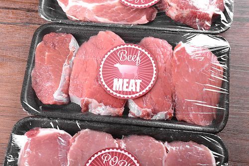 Three Trays of Beef Meat Wrapped in Plastic on A Wooden Table — Prime Meats NT in Coconut Grove, NT