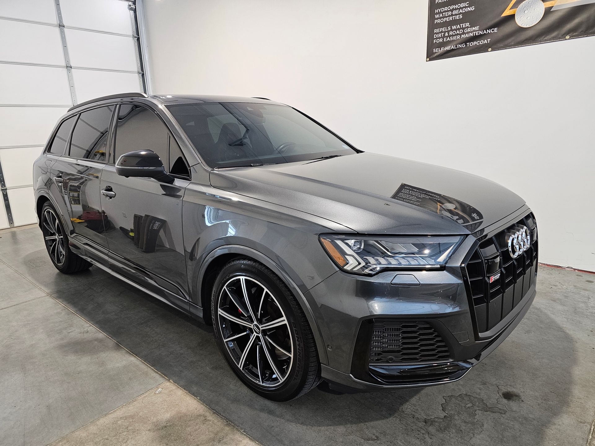 Gray Audi SUV in a showroom, viewed from the front-left side.