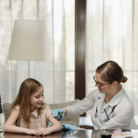 Doctor giving a vaccine shot to a smiling child in a clinic room