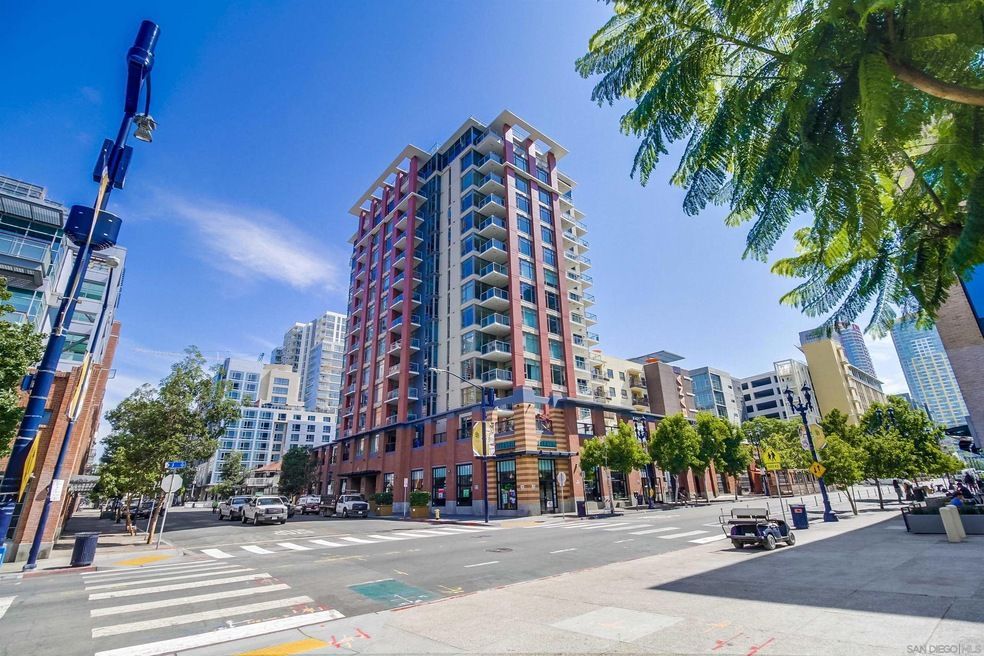 A tall building is sitting on the corner of a city street.