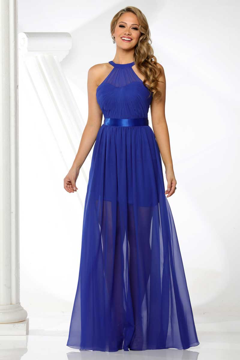 Woman in a royal blue halter gown standing against a white studio backdrop.