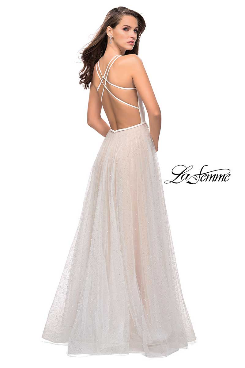 Woman in a white backless gown posing against a white background