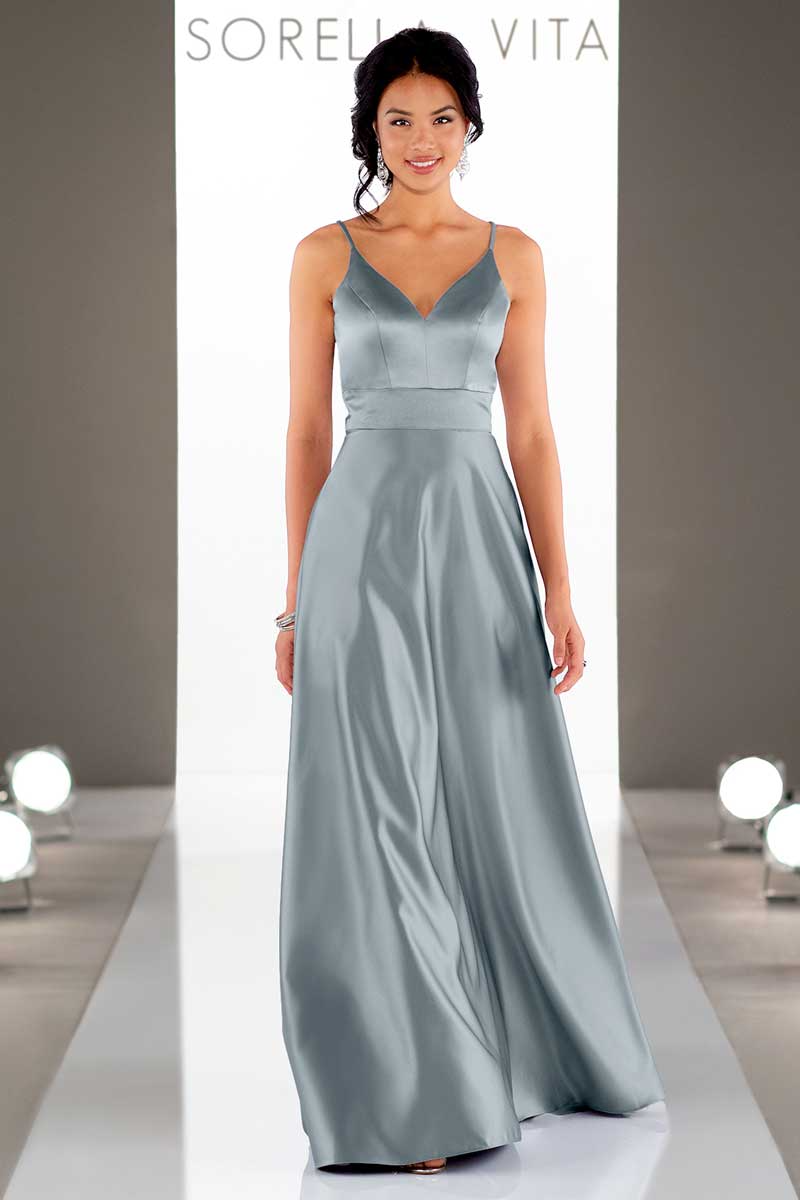 Model in a silver satin gown on a runway with Sorella Vita backdrop