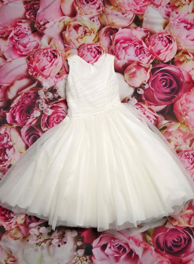 White sleeveless dress with tulle skirt on a pink rose floral background