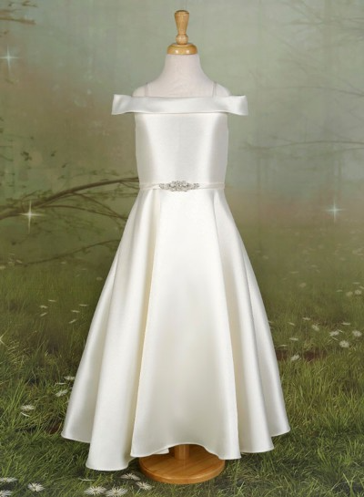 White satin off-shoulder dress on a mannequin against a green textured backdrop.
