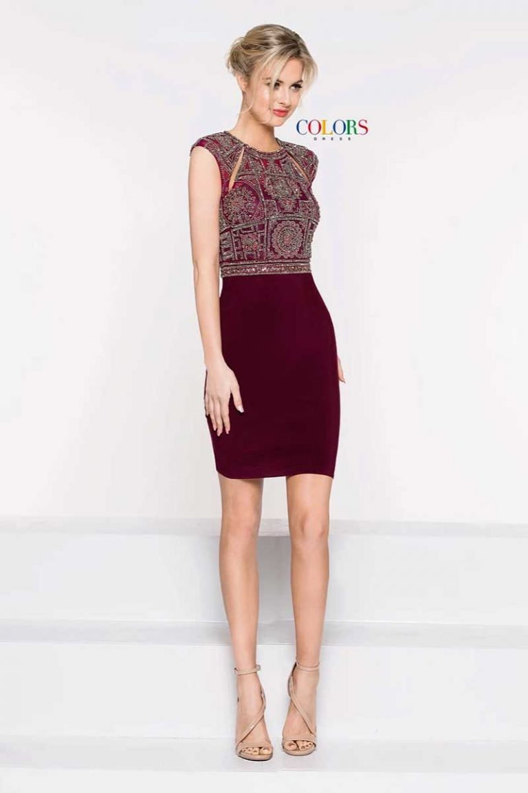 Woman in patterned sleeveless top and burgundy skirt standing on a white runway against a white backdrop