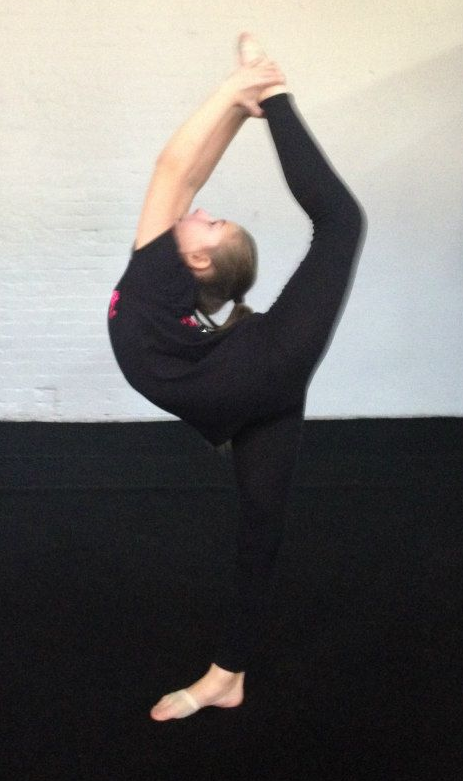 Young energetic dancer performs modern dance pose