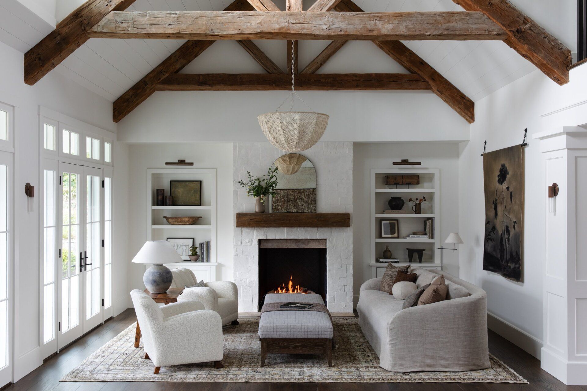 Bright living room with white armchairs, a fireplace, and exposed wooden beams | Beth Ellinthorpe Realtor | Luxury Real Estate