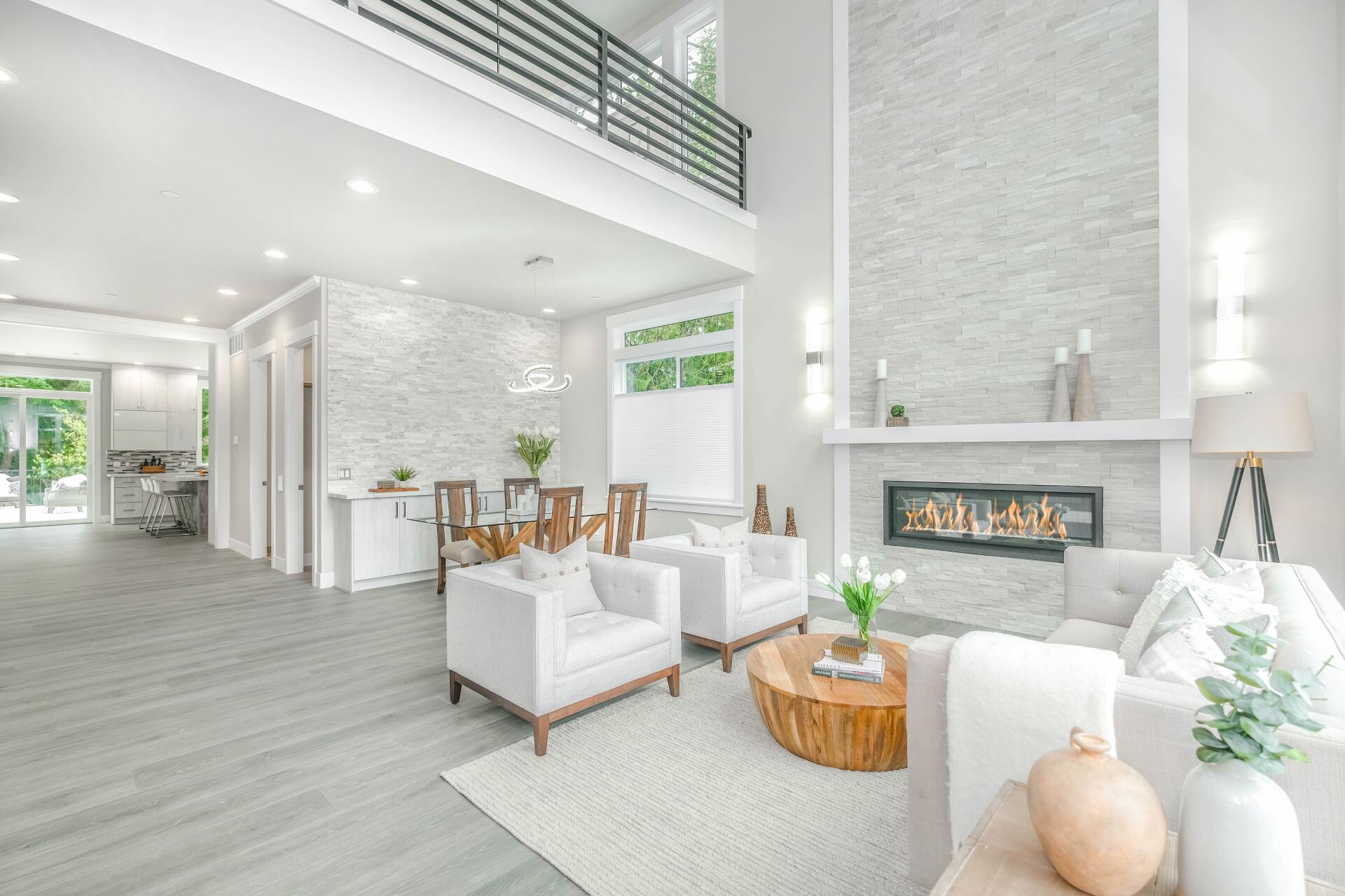 Bright modern living room with white furniture, stone fireplace, and high ceilings | Beth Ellinthorpe Realtor | Luxury Real Estate