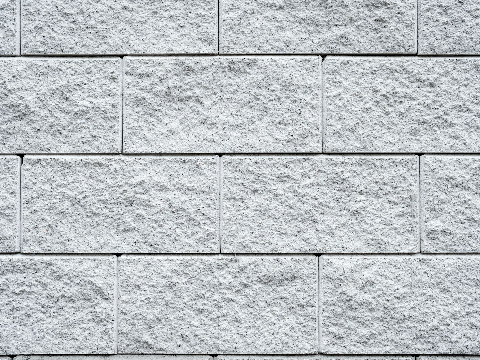 Gray concrete block wall with textured surface, arranged in horizontal rows.