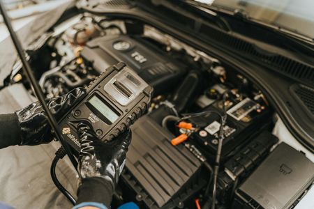 A person is working on the engine of a car.