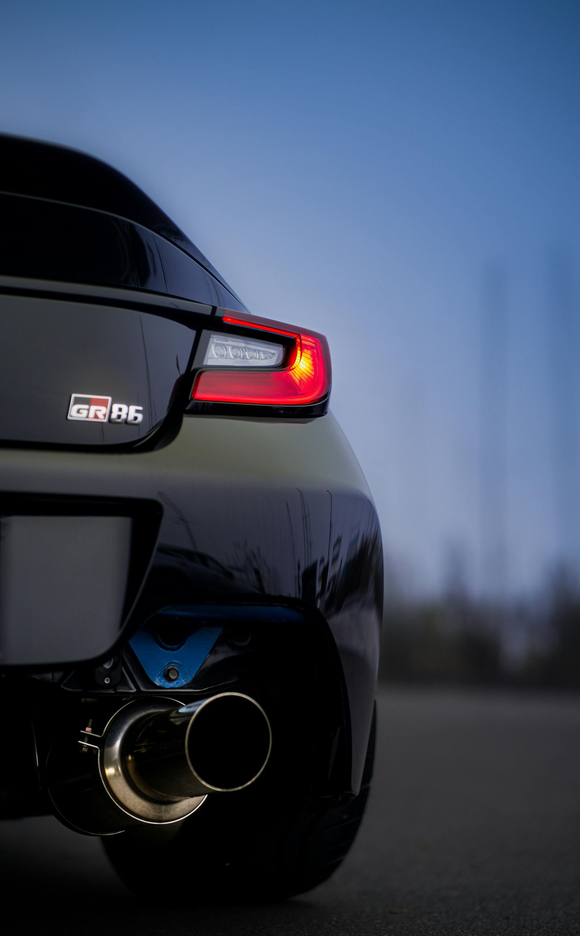 A close up of the back end of a car with a exhaust pipe.