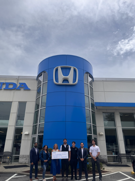 Kelly Barch with donors standing in front of a Honda dealership