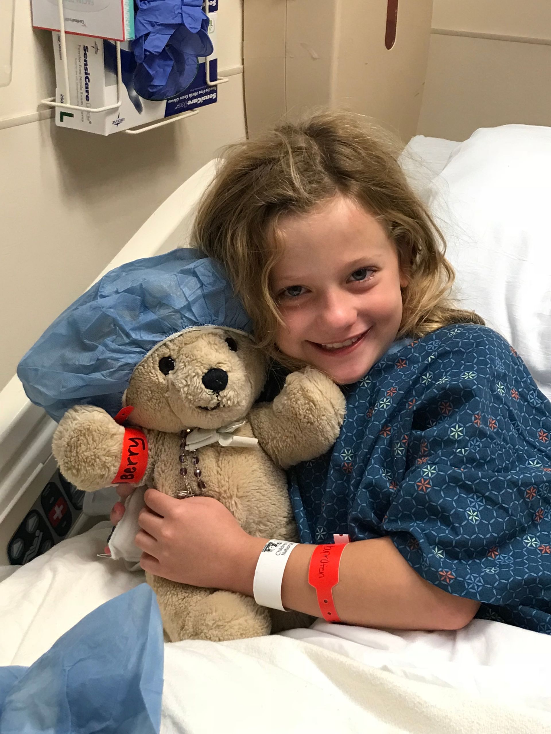 LBF Hero Maddie Highfill holding teddy bear in hospital bed