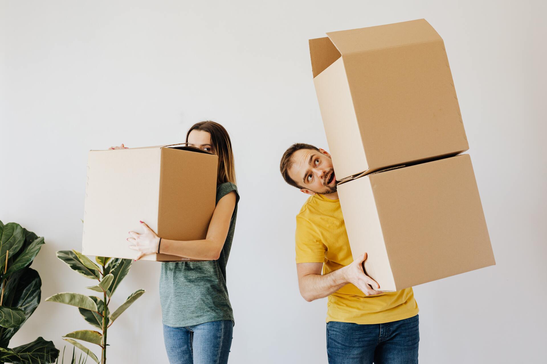 Man and woman carrying tall boxes