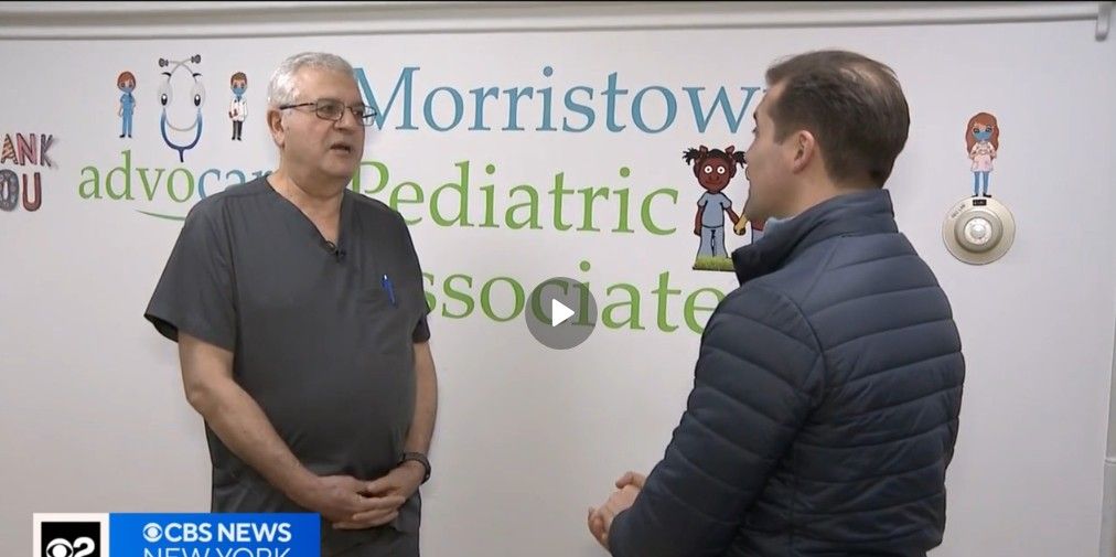 Two men are talking in front of a whiteboard that says morristown pediatric associate