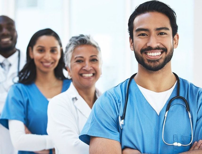 A group of doctors and nurses are posing for a picture