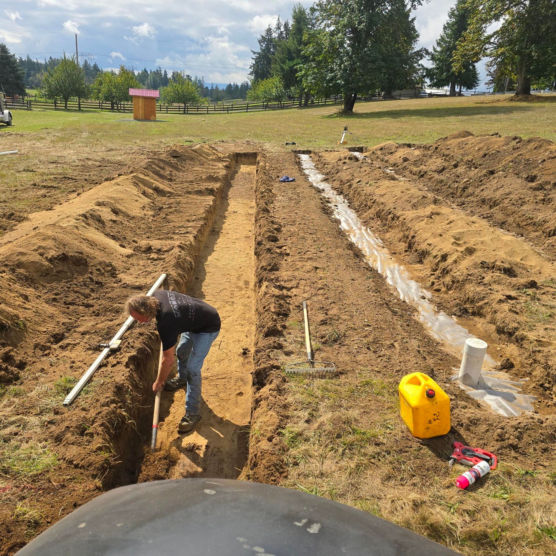 A man is digging a trench in the dirt