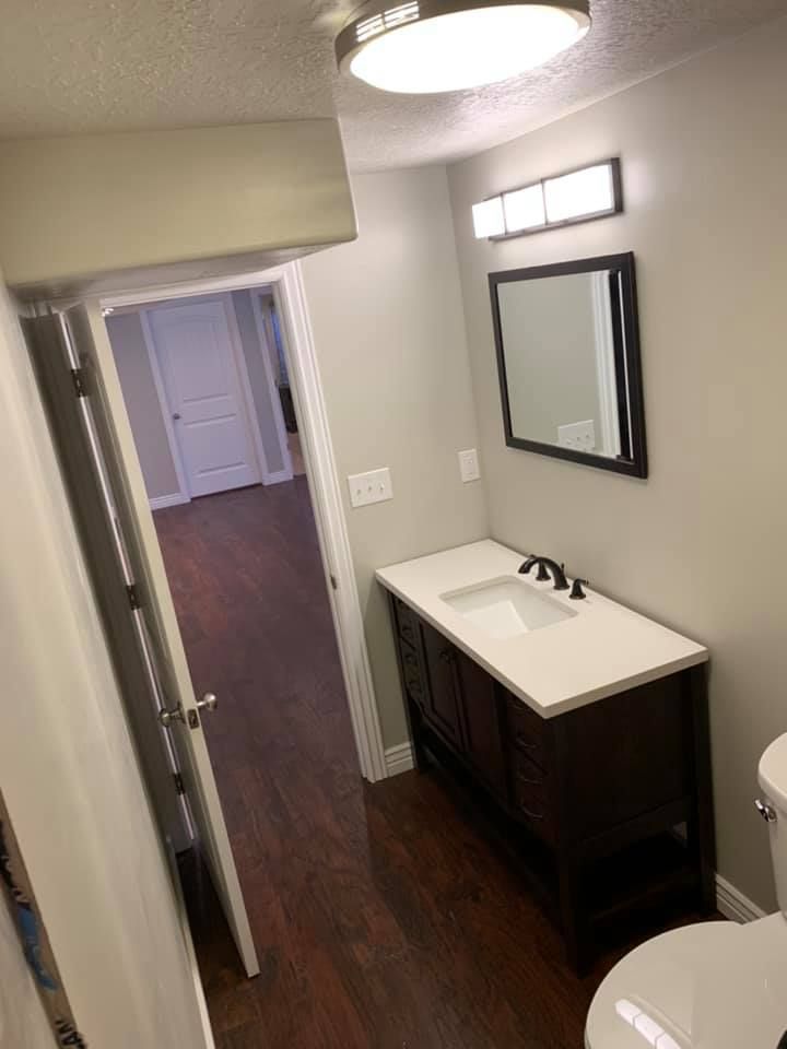 A bathroom with a sink , toilet and mirror.