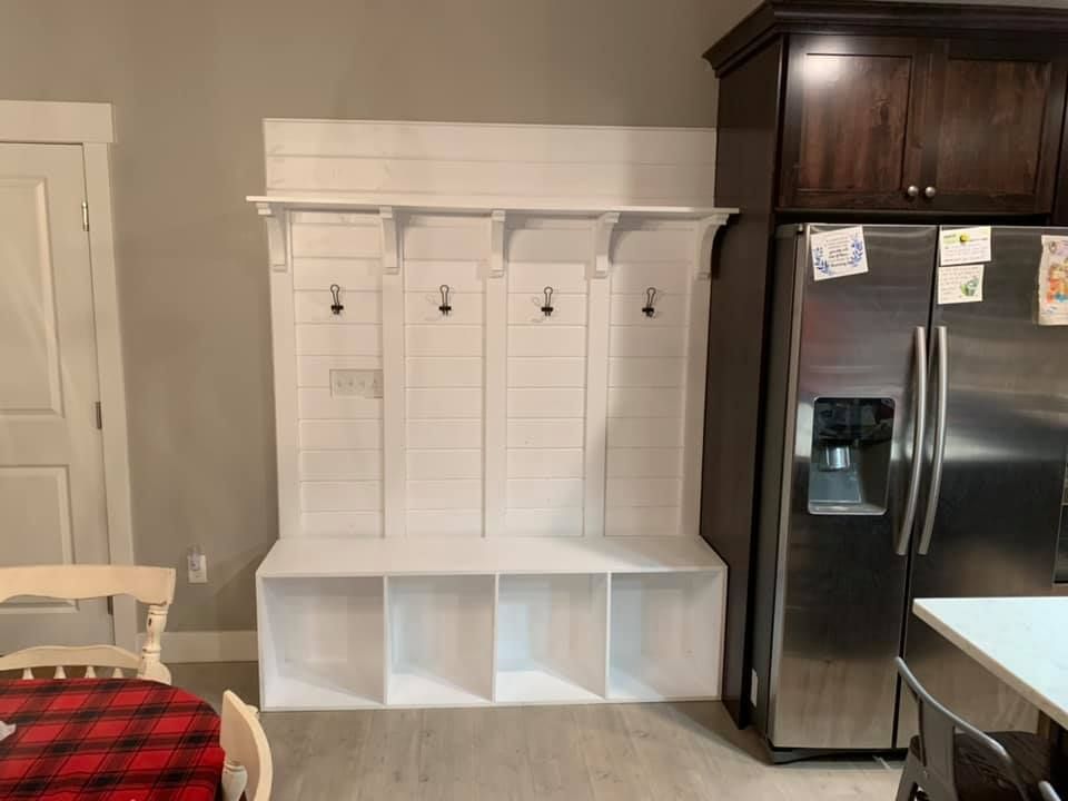 A kitchen with a stainless steel refrigerator and a bench.