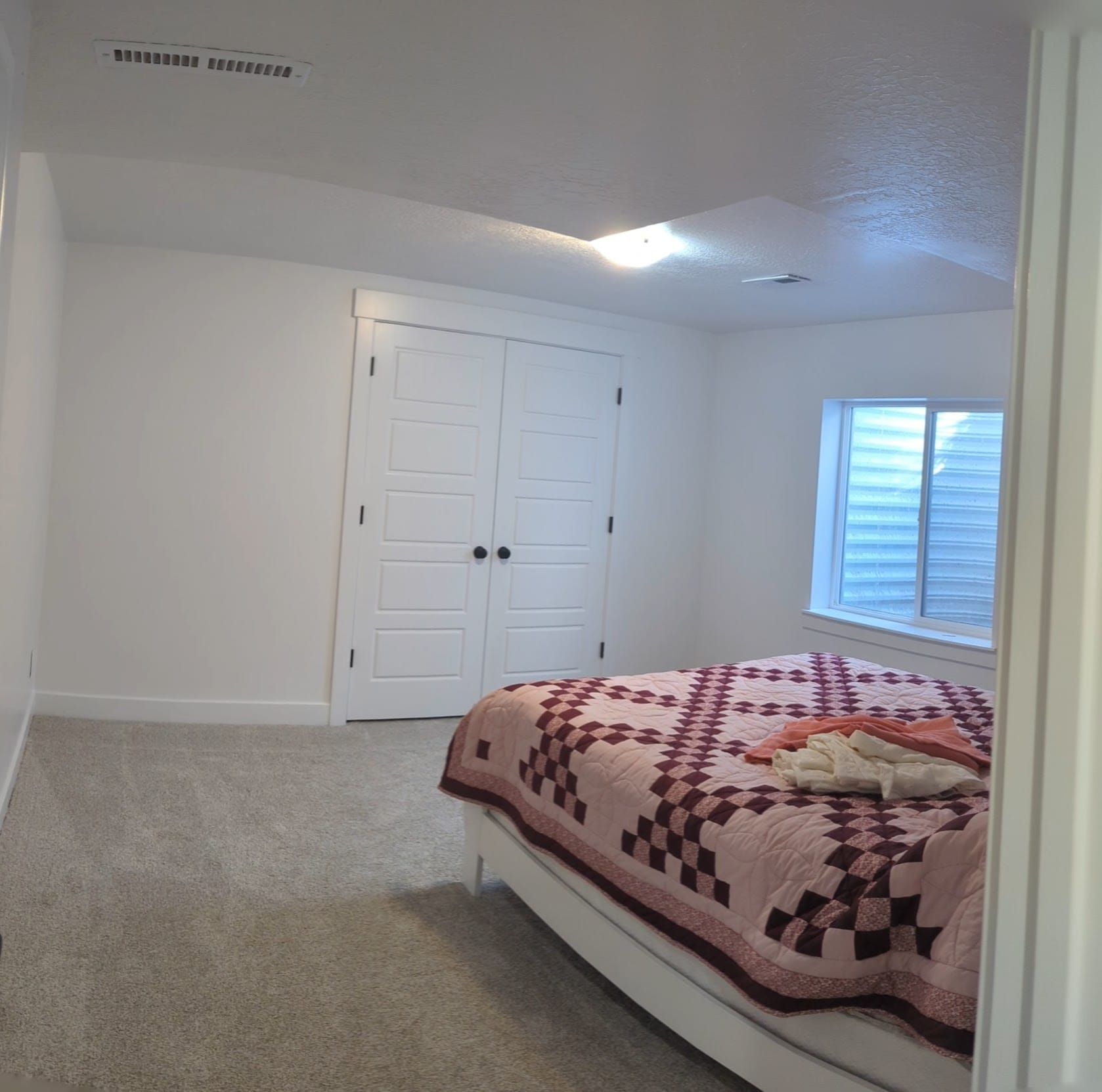 A bedroom with a large bed and a window