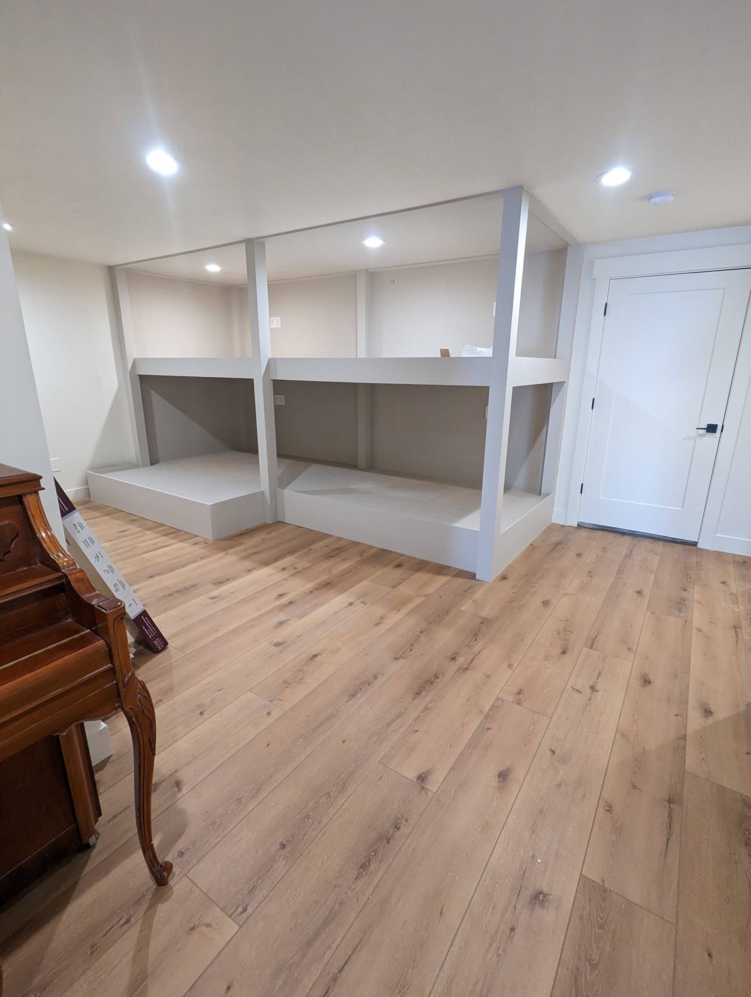 A room with bunk beds and a piano in it.