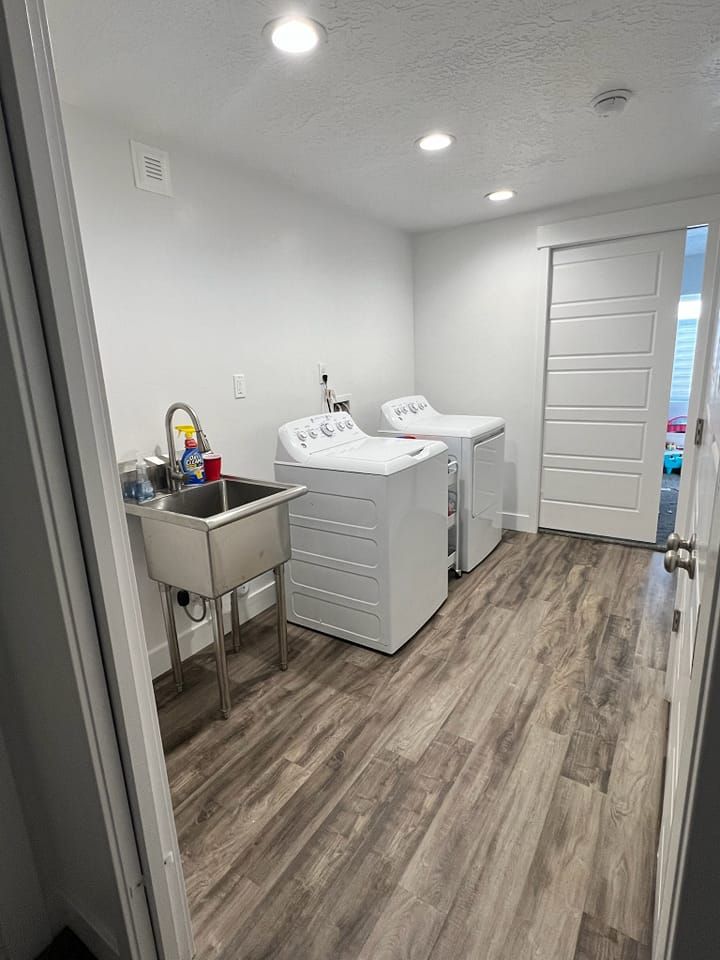 A laundry room with a washer and dryer and a sink.