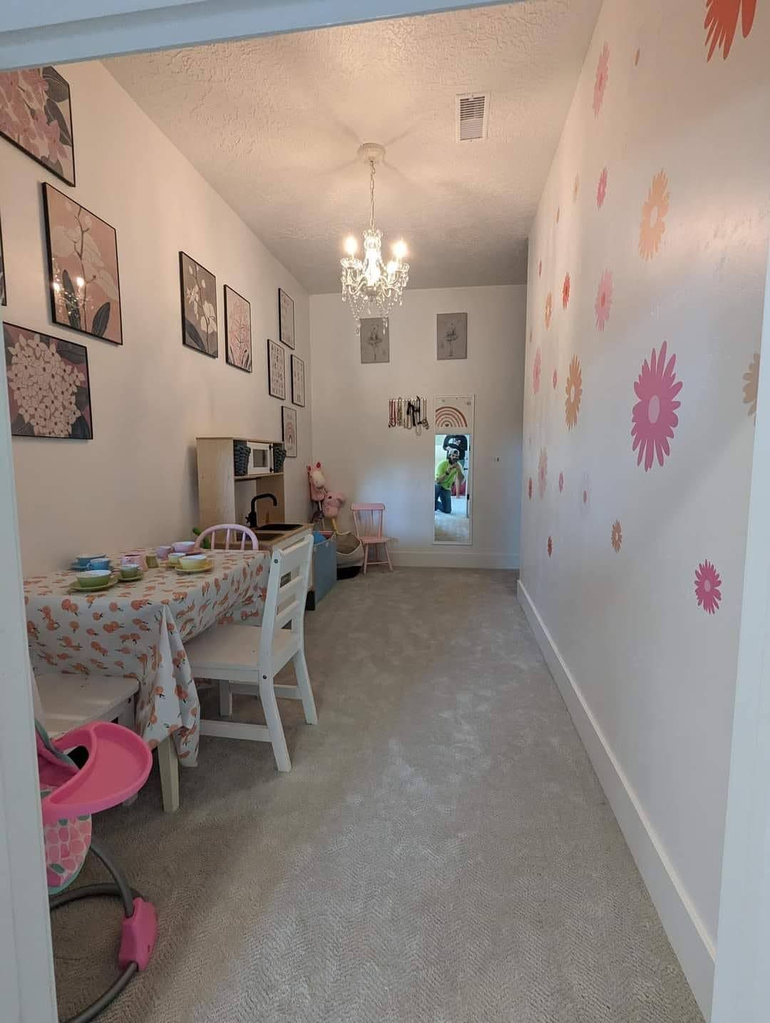 A long hallway with a table and chairs in it.